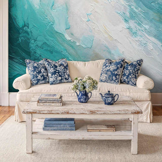 Coastal abstract wallpaper featuring turquoise waves and cream tones, displayed in cottage living room with white sofa
