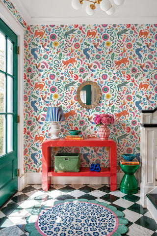 Colorful animal and floral folk wallpaper with leopards and birds, in a bright entryway with checkered floor