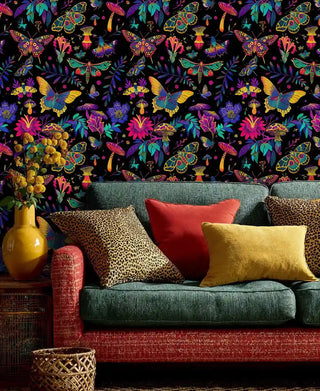 Colorful mystical butterfly wallpaper with florals and moths, shown in modern living room with leopard print pillows