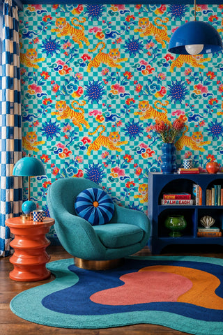 Colorful tiger and cloud wallpaper on checkered teal background, in a reading nook with swivel chair
