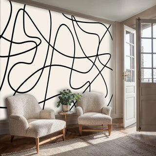 contemporary line art wallpaper with organic black curves, displayed in seating area with neutral armchairs