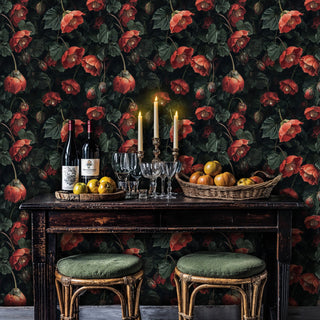 Coral hellebore floral wallpaper shown in dining setting with candlesticks, wine bottles and rustic wooden table