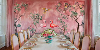 Coral pink tropical wallpaper with flamingos and parrots, displayed in luxury dining room with gold-framed chairs