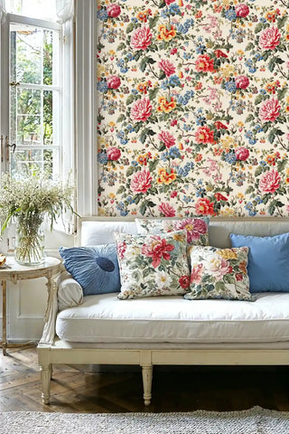 Cottage garden floral wallpaper with vibrant peonies and wildflowers in a bright living room with white sofa