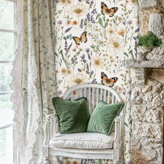 Cottage garden wallpaper with butterflies and wildflowers, shown in stone-walled room with white chair and green cushions