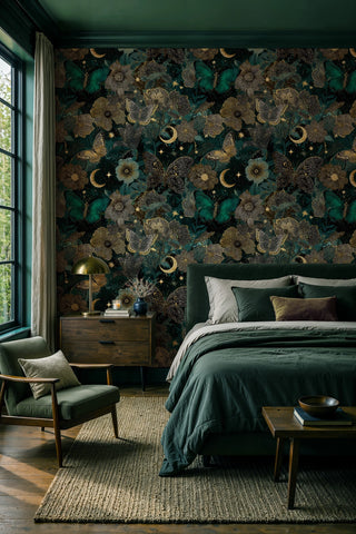 Dark botanical butterfly wallpaper with gold crescents and blooms in a moody green bedroom with brass lamp