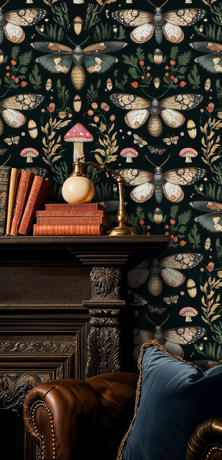 Dark botanical moth wallpaper with detailed wings and berries, in a study with an ornate fireplace and books