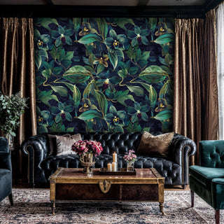 Dark botanical orchid wallpaper with detailed blooms and leaves, in maximalist living room with vintage trunk