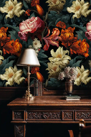 Dark botanical wallpaper displaying vibrant blooms in traditional study with brass lamp and books