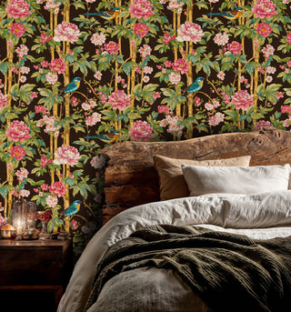 Dark botanical wallpaper featuring turquoise birds and coral flowers, displayed in a cozy bedroom with wood headboard