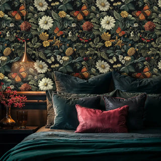 Dark botanical wallpaper with butterflies and wildflowers in a moody bedroom with velvet pillows