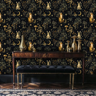 Dark botanical wallpaper with foxes and moon motifs displayed behind wooden console with brass decor