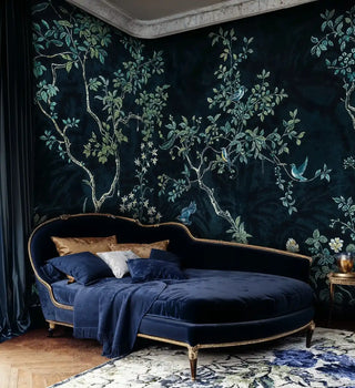 Dark chinoiserie wall mural with birds and flowering vines, showcased in luxurious bedroom with curved velvet daybed