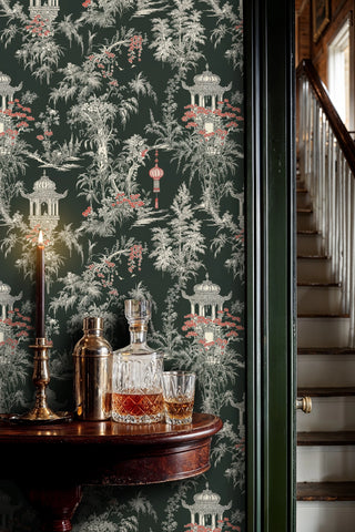 Dark chinoiserie wallpaper with pagodas and red lanterns, shown in an entryway with crystal decanters