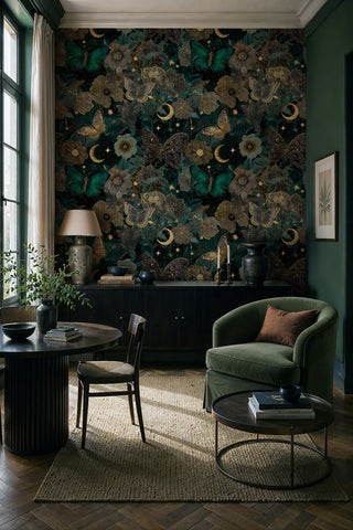 Dark floral butterfly wallpaper with gold stars and moons in a green study with olive armchair and black credenza