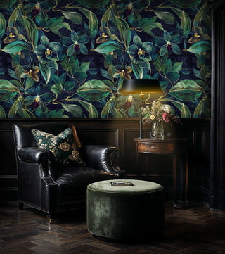 Dark floral orchid wallpaper with navy background and green leaves, in elegant living room with leather sofa