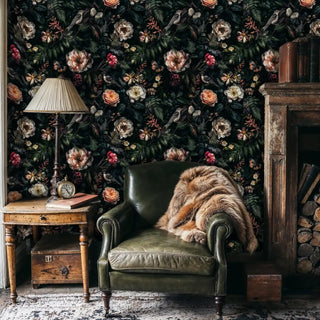 Dark floral wallpaper featuring songbirds and blooms in vintage study with leather chair and fur throw