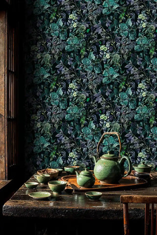 Dark floral wallpaper showing intricate botanical pattern, featured in rustic dining space with ceramic tea set on wooden table