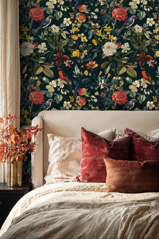 Dark floral wallpaper with birds and vibrant blooms, shown in elegant bedroom with beige headboard