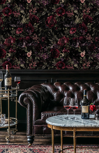 Dark floral wallpaper with burgundy roses and purple flowers on black, in elegant living room with leather sofa