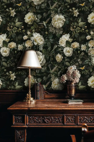 Dark floral wallpaper with cream roses and hummingbirds in traditional study with ornate desk