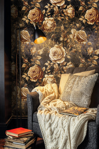 Dark floral wallpaper with gilded roses on black, with floor lamp and knit throw on chair