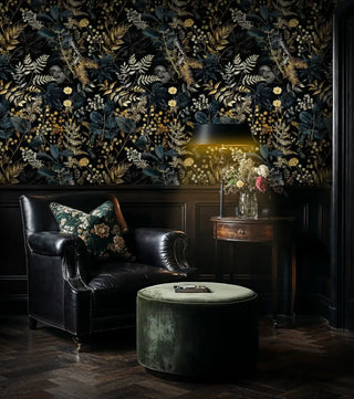 Dark floral wallpaper with golden botanicals displayed in sophisticated study with leather chair