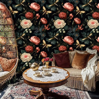 Dark floral wallpaper with pink peonies and golden dragonflies in a moody, romantic style, shown in a boho living room with a wicker hanging chair.