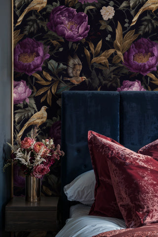 Dark floral wallpaper with purple blooms and cream flowers displayed in sophisticated bedroom with brass accents