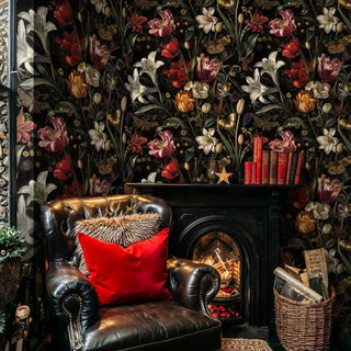 Dark floral wallpaper with tulips and lilies, shown in cozy living room with leather armchair and fireplace