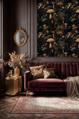 Dark forest wallpaper with spotted mushrooms and berries shown in sophisticated living room with burgundy velvet sofa