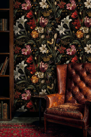 Dark garden wallpaper with butterflies and lush blooms, in a study with a tufted leather armchair and bookshelf