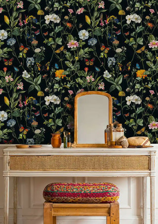 Dark garden wallpaper with monarch butterflies and pink daisies, in warm entryway with wooden bench and mirror