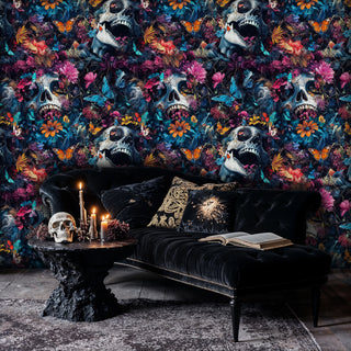 Dark gothic wallpaper featuring skulls and pink florals in moody bedroom with black velvet chaise