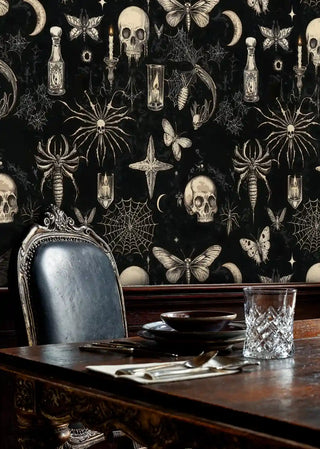 Dark gothic wallpaper with butterflies and candles shown in sophisticated study with ornate blue chair