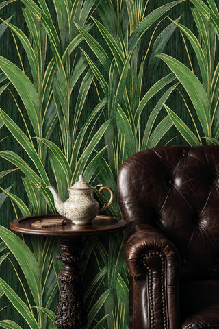 Dark green botanical grass wallpaper beside a tufted leather armchair and porcelain teapot on side table