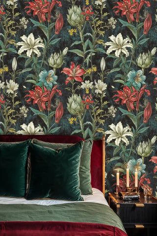 Dark lily wallpaper featuring colorful blooms in moody bedroom with burgundy velvet headboard