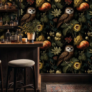 Dark owl botanical wallpaper with pumpkins, next to a home bar with bottles and a stool