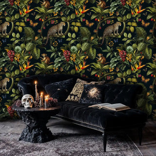 Dark tropical wallpaper with leopards and monkeys, displayed in moody bedroom with black velvet chaise