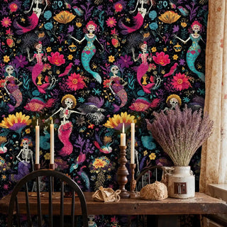 Day of the Dead mermaid wallpaper with skeleton mermaids and vibrant flowers, shown in rustic dining room with candles