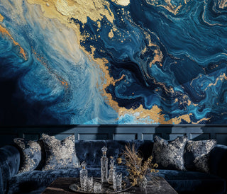 Deep blue and gold marble wall mural with flowing veins above a navy velvet sofa with crystal decanters on table