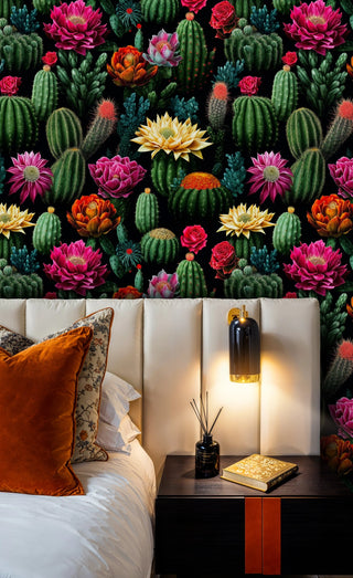 Detailed view of a cactus bloom wallpaper, green and black, shown with an orange pillow