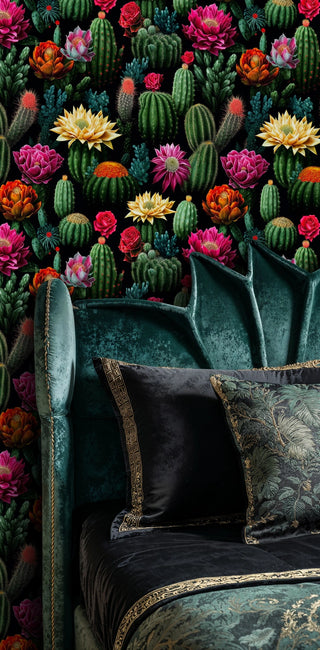 Detailed view of a cactus bloom wallpaper in green-on-black, shown behind a velvet headboard