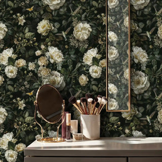 Detailed view of a dark floral Wallpaper with ivory roses and green leaves, hummingbirds; elegant style; gold tabletop mirror.