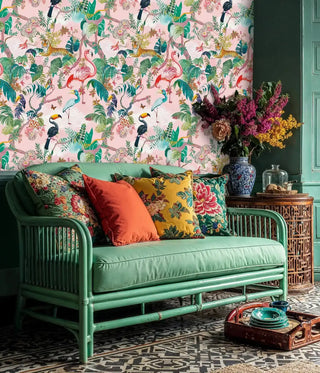 Detailed view of a tropical jungle wallpaper with flamingos and tigers, in pink and green, in an eclectic living room with a green bamboo sofa.