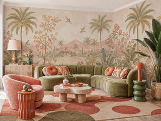 Detailed view of a tropical scenic Wall Mural with palms, flowers and lake, blush and sage, in a living room with curved green sofa