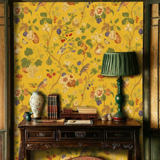 Detailed view of an Orchard Birds Wallpaper with birds and fruit on mustard yellow, with green lamp