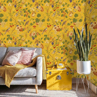 Detailed view of an Orchard Birds Wallpaper with fruit on mustard yellow, with trunk and phone