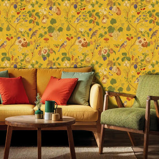 Detailed view of an Orchard Birds Wallpaper with vines on mustard yellow, shown with sofa