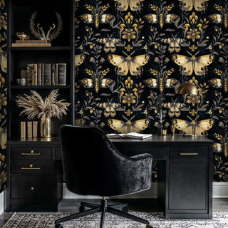 Detailed view of black-gold moth wallpaper, shown with a black desk and lamp